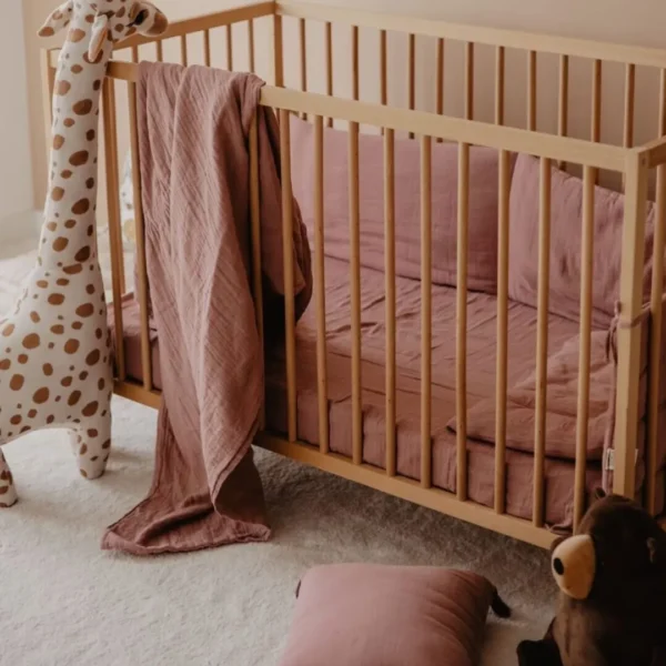 posteljina za bebe od muslina prljavoroze boje na krevecu