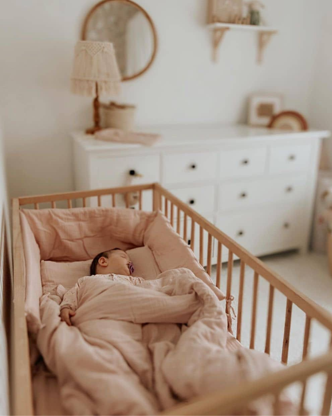 posteljina za bebe od muslina u drvenom krevecu. Beba spava prekrivena prekrivacem u navlaci za prekrivac od muslina