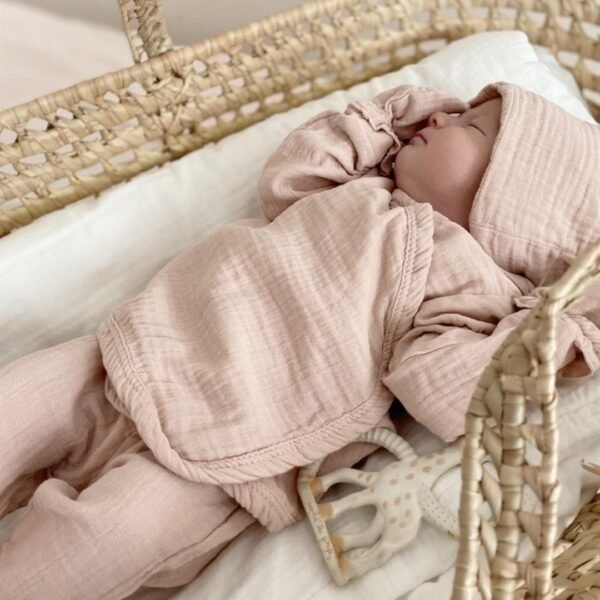 set za iznosenje bebe od muslina roze boje bluzica na preklop pantalone kapa rukavice i portikla sa zakopcavanjem na dva nivoa na bebi