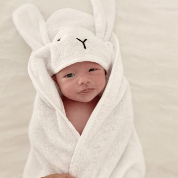 peskir za bebe sa usima i motivom zeke bele boje obavijen oko novorodjene bebe