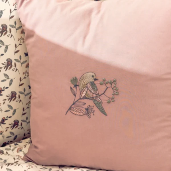 posteljina za bebe set od sedam delova sa motivom ptice i grancica jastuk sa vezom prikazan izbliza