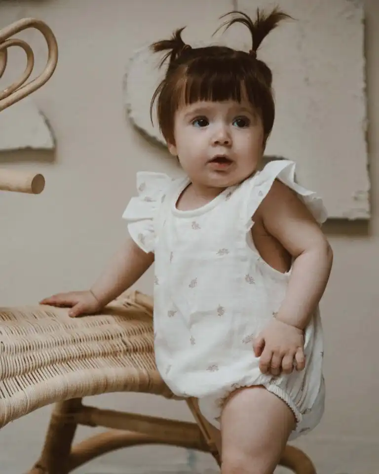 romper od muslina sa karnerom na ramenima krem boje sa motivom lisca na devojcici koja se drzi za drvenu stolicu