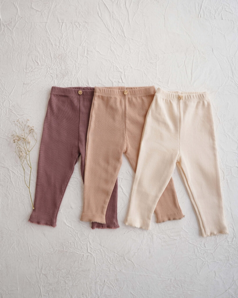 helanke za bebe od rebrastog pamuka u krem ljubicastoj i bez boji slozene jedne na druge na beloj pozadini