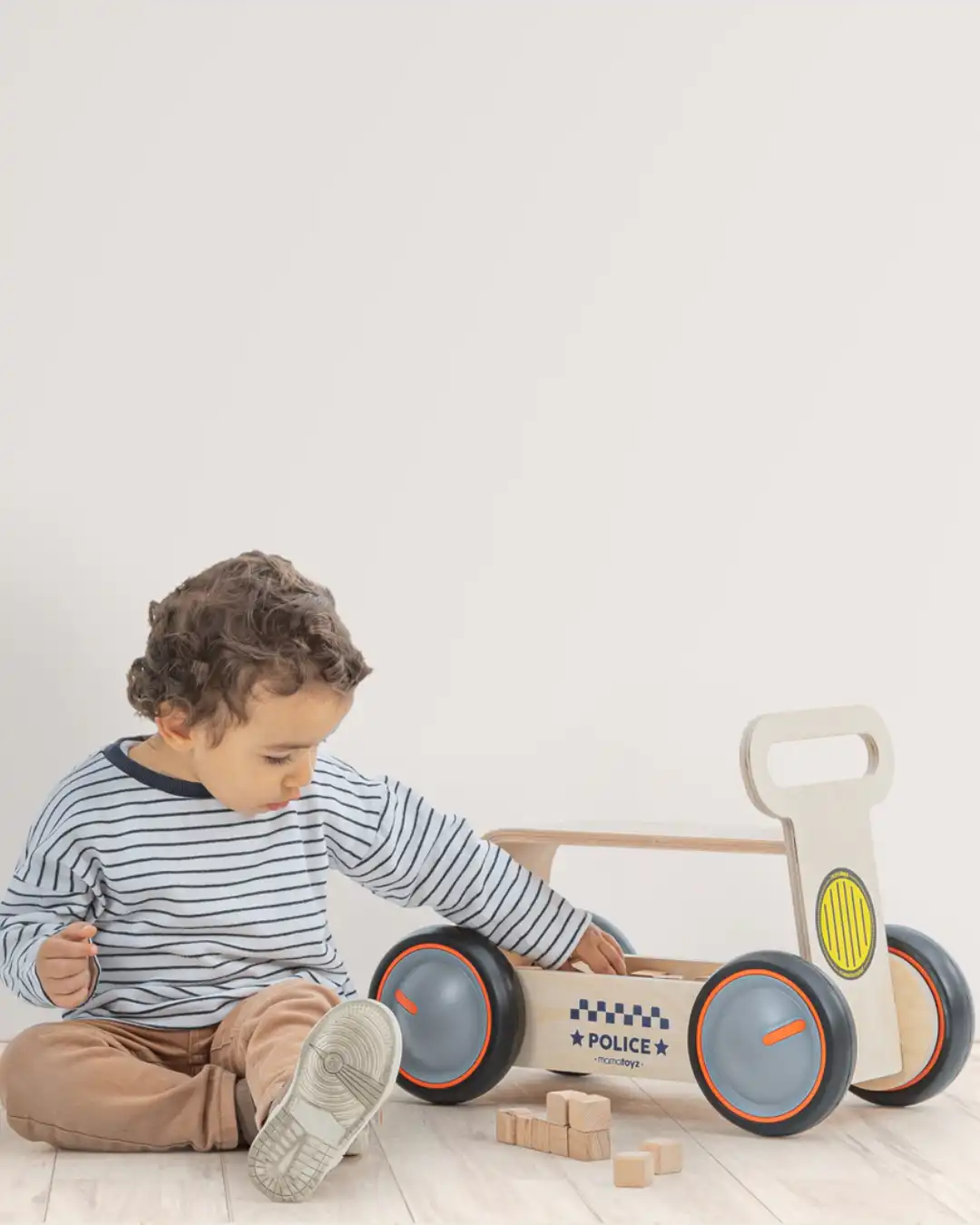 guralica za bebe sa sedistem od drveta i natpisom police prikazan decak pored guralice