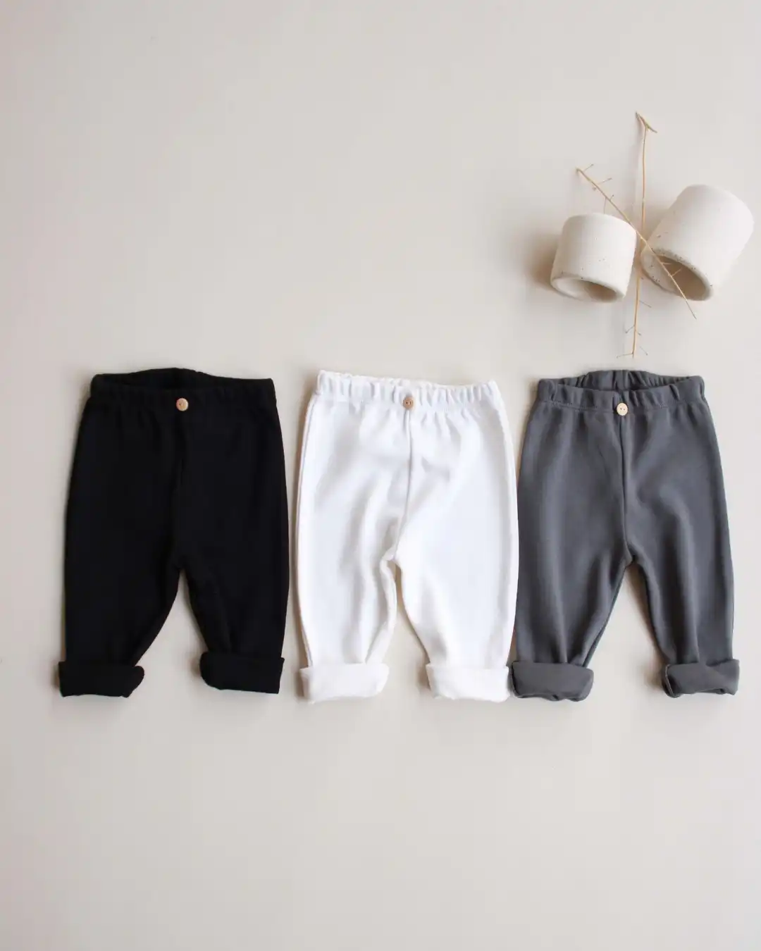 helanke od pamuka u crnoj, sivoj i beloj boji na pozadini boje peska