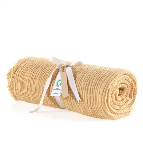 prekrivac od muslina oker boje umotan i zavezan masnicom