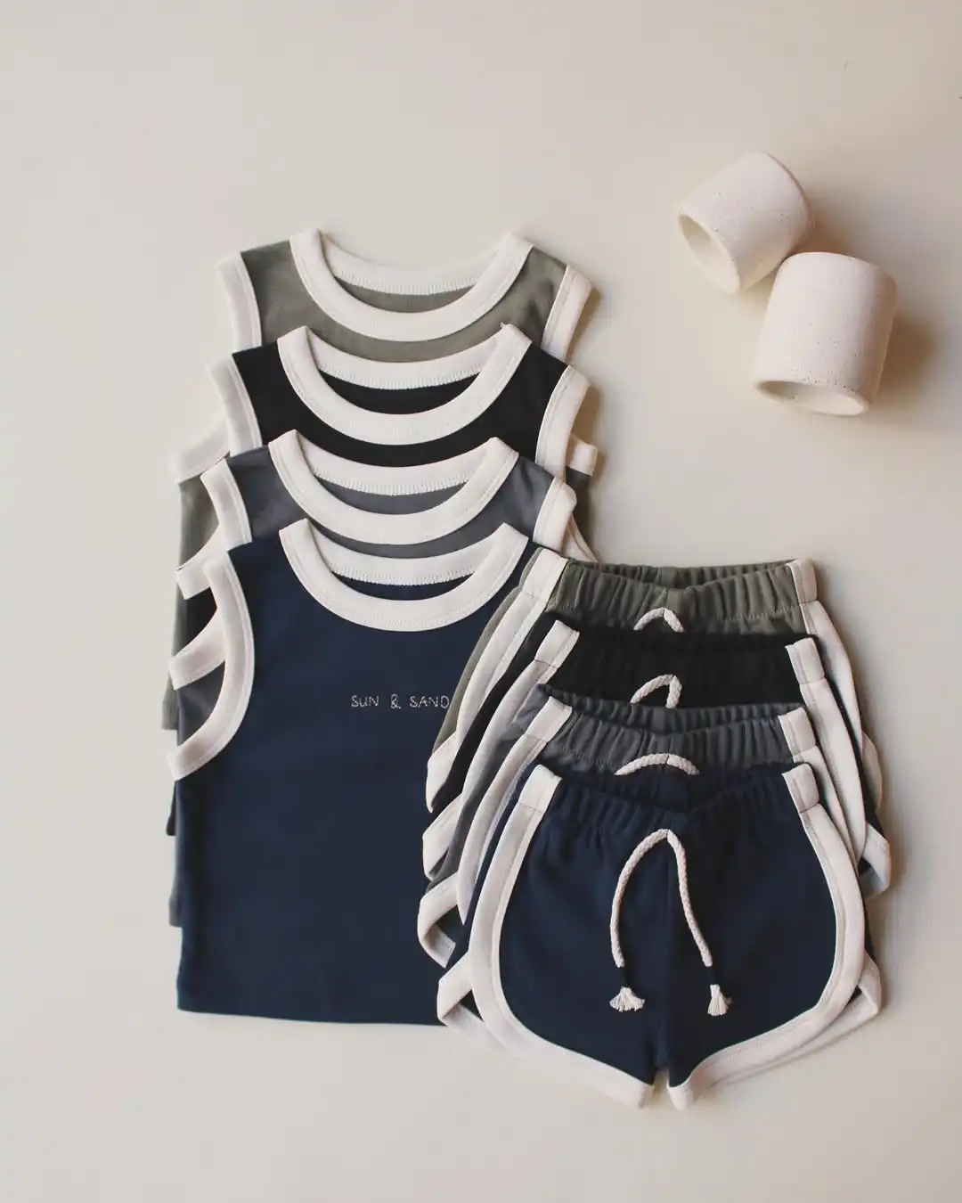 komplet sorc i majica na bretele sa belim rubovima crna teget maslinasta i siva boja na pozadini