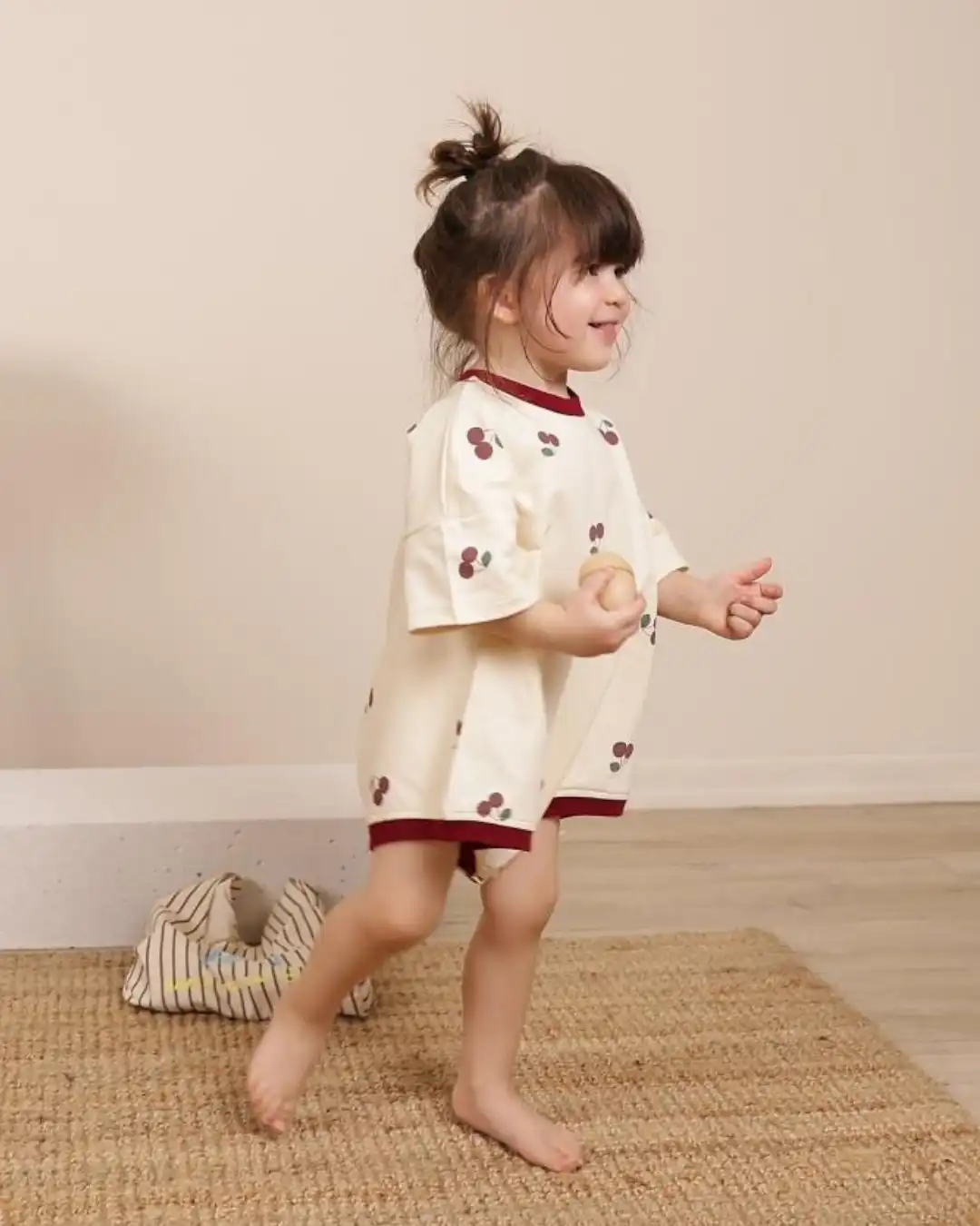 romper za bebe krem boje sa bordo rubovima i motivom tresnjica na devojcici