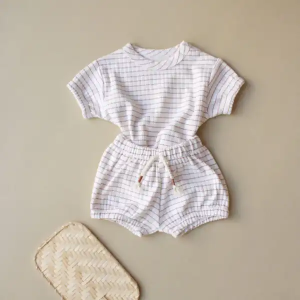 komplet sorts i majica kratkih rukava krem boje sa motivom kockica braon boje na pozadini