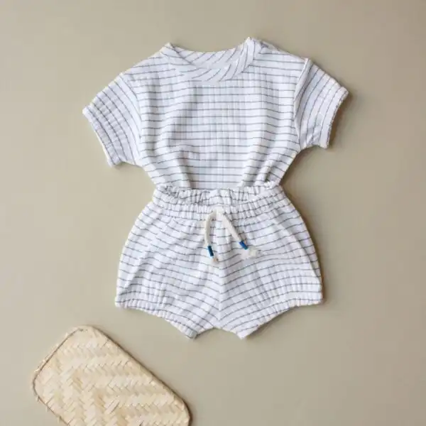 komplet sorts i majica kratkih rukava krem boje sa motivom kockica plave boje na pozadini