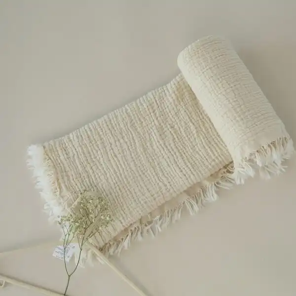 prekrivac od muslina od cetiri sloja krem boje prikazan izbliza