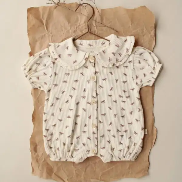 romper sa karnerima krem boje sa motivom masnica na pozadini