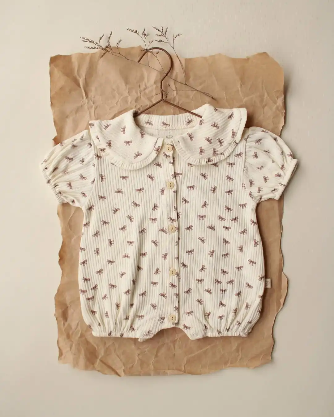 romper sa karnerima krem boje sa motivom masnica na pozadini