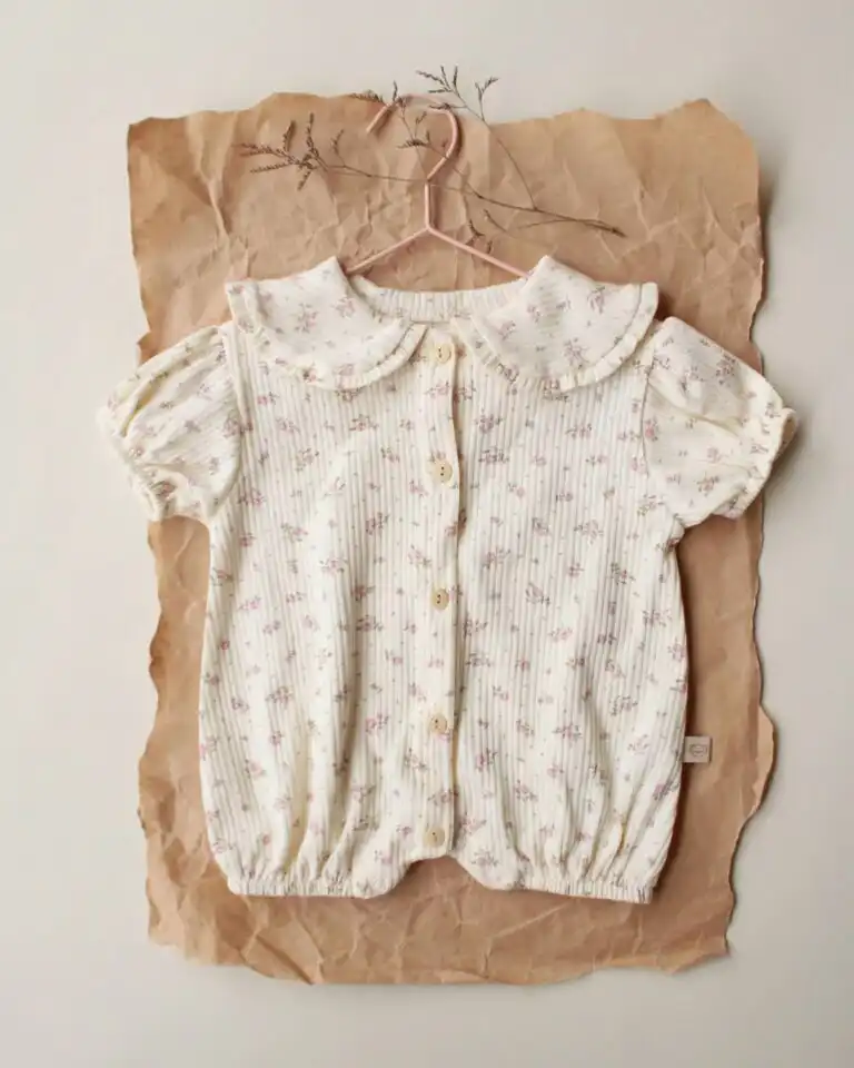 romper sa karnerima krem boje sa motivom rozih svetica na pozadini