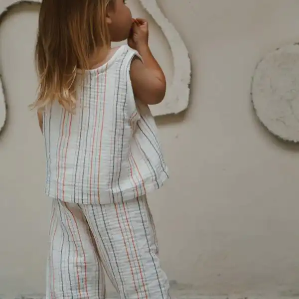 komplet majica i pantalone od muslina na strafte narandzaste boje prikazan sa ledja na devojcici