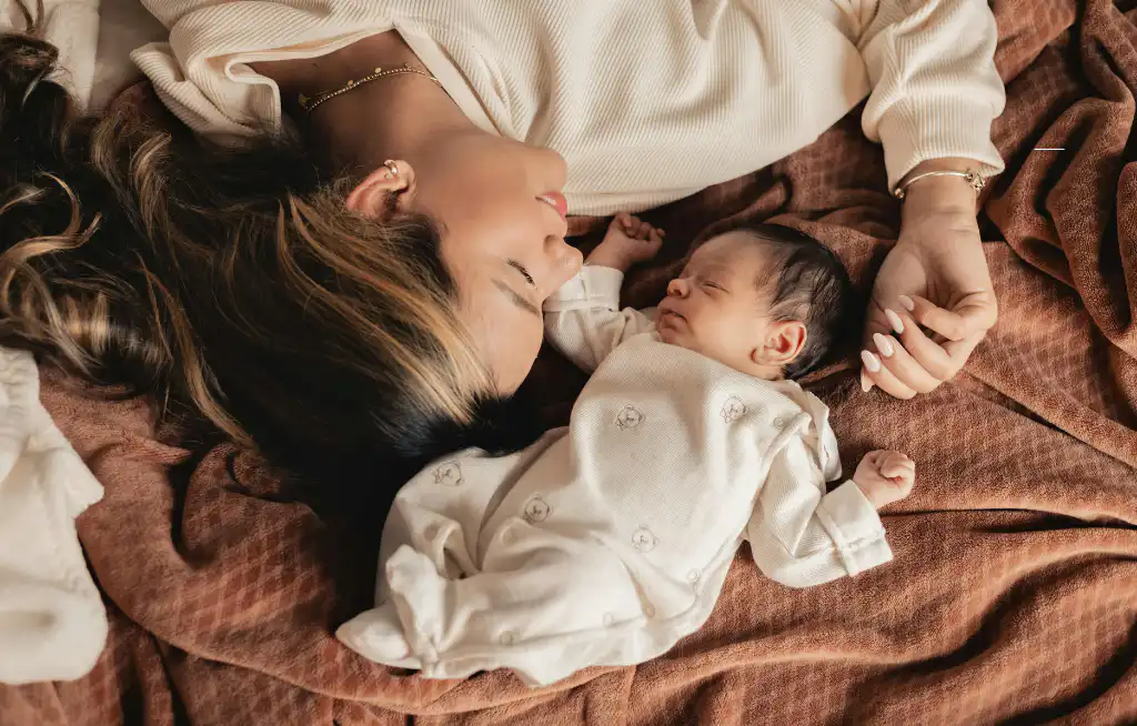 kako uspavati bebu mama i beba leže na krevetu posteljina je braon boje