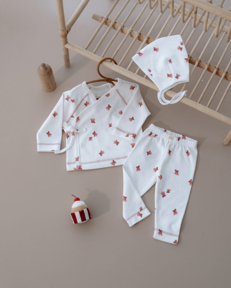 komplet u krem boji od tri dela gornji deo kapa na vezivanje i pantalone sa motivom na pink zvona