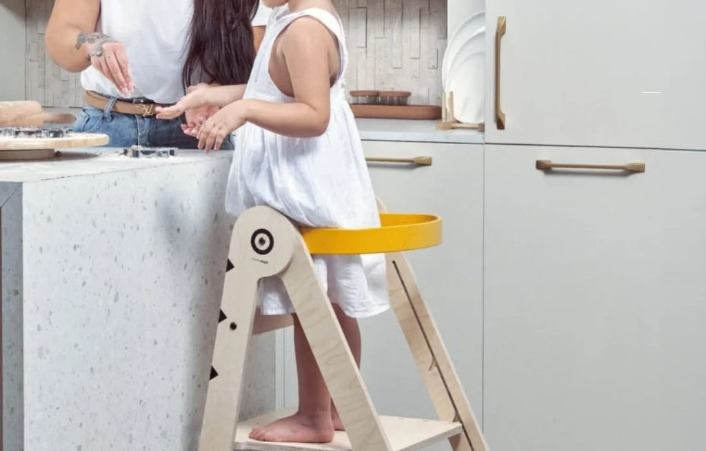 montessori nameštaj dete stoji na tornju za učenje u kuhinji