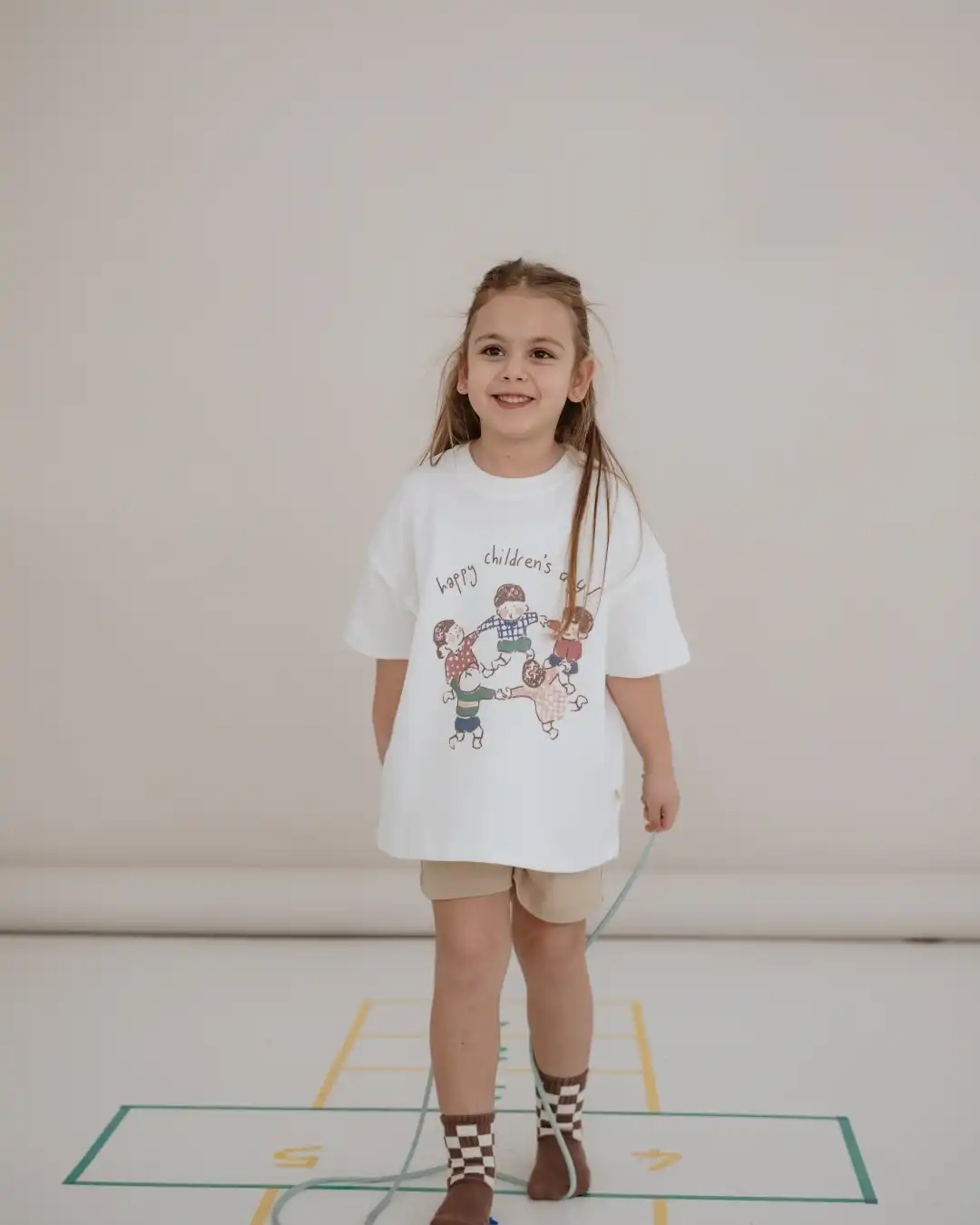 majica bele boje sa printom 5 dece koja se drze za ruke i vrte u krug sa natpisom happy children's day