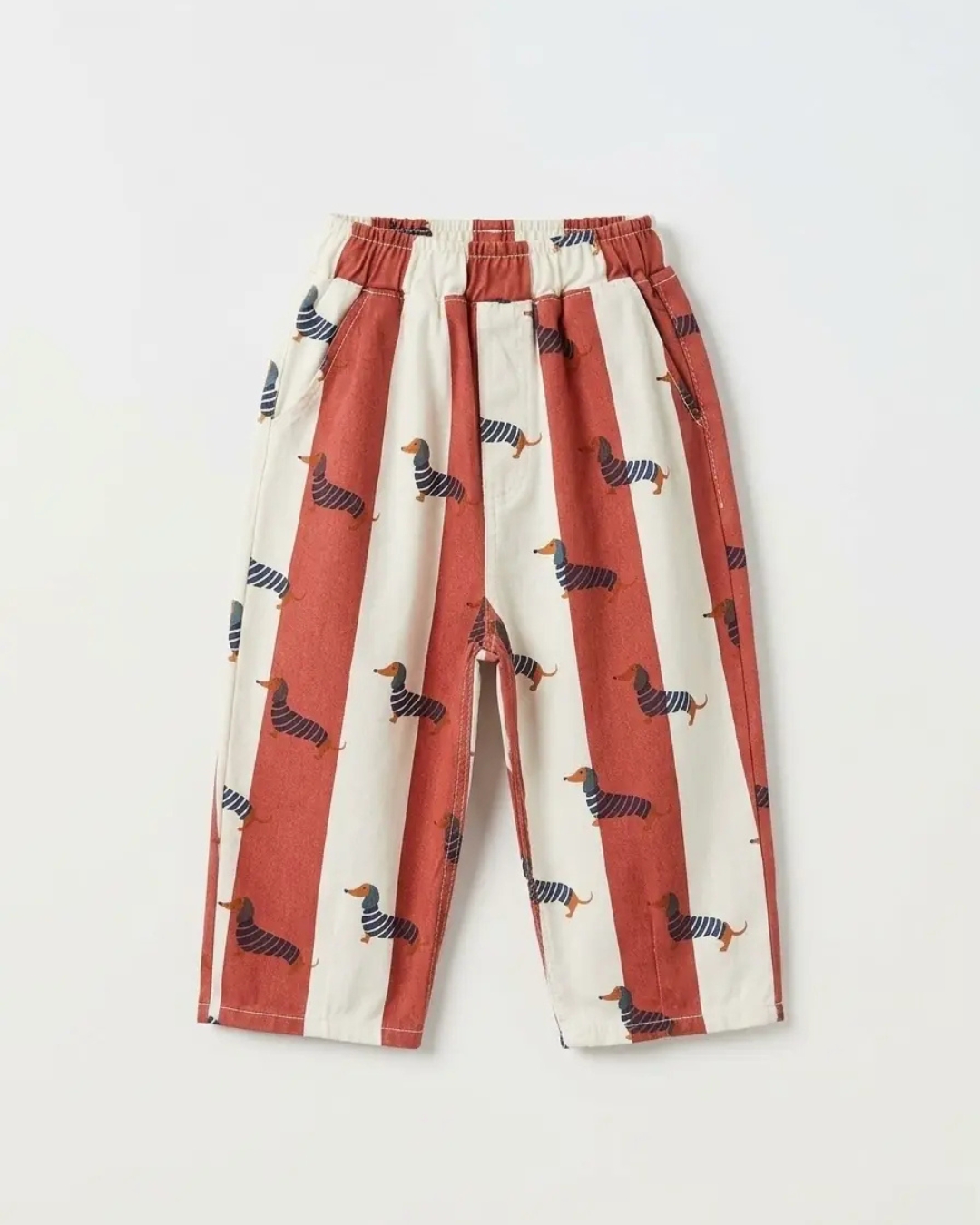 pantalone u beloj boji sa crvenim prugama i printom psa u crnoj boji