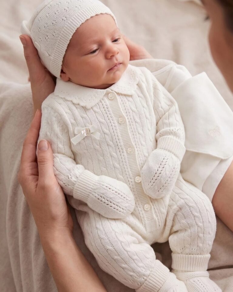 set za bebe u beloj boji od 8 delova, bodi dugih rukava, kombinezon na zakopčavanje, kapica, pamučna maramica, ćebe, rukavice, čarapice i traka za ćebe